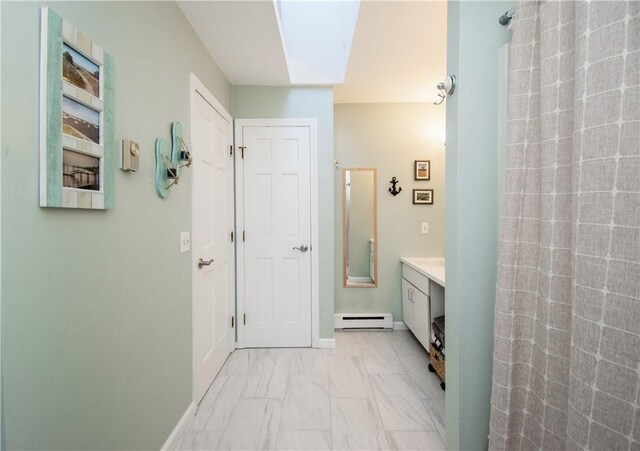 bathroom featuring a baseboard heating unit, vanity, and a shower with shower curtain