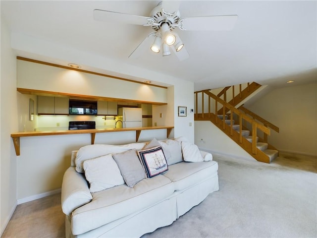 carpeted living room featuring ceiling fan and sink