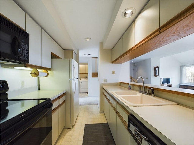 kitchen with sink, cream cabinetry, black appliances, and washer / dryer