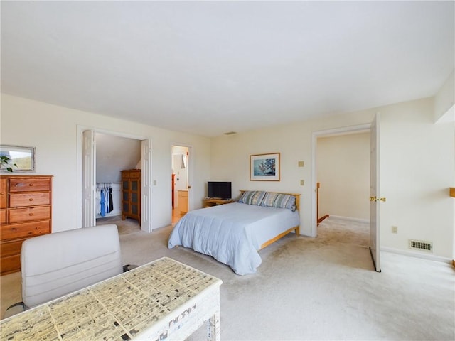 bedroom featuring ensuite bath and light colored carpet