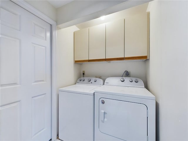 washroom with cabinets and washer and clothes dryer