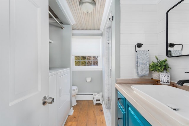 bathroom featuring separate washer and dryer, hardwood / wood-style flooring, vanity, and toilet