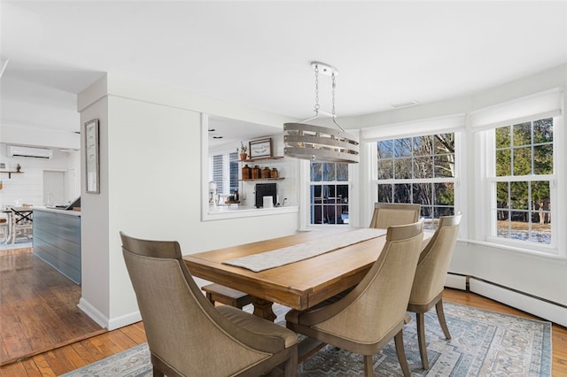 dining area featuring hardwood / wood-style floors and a wall mounted air conditioner