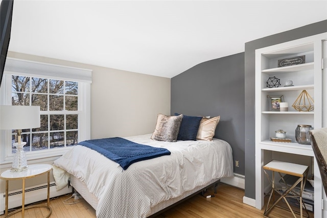 bedroom with vaulted ceiling, wood-type flooring, and a baseboard radiator