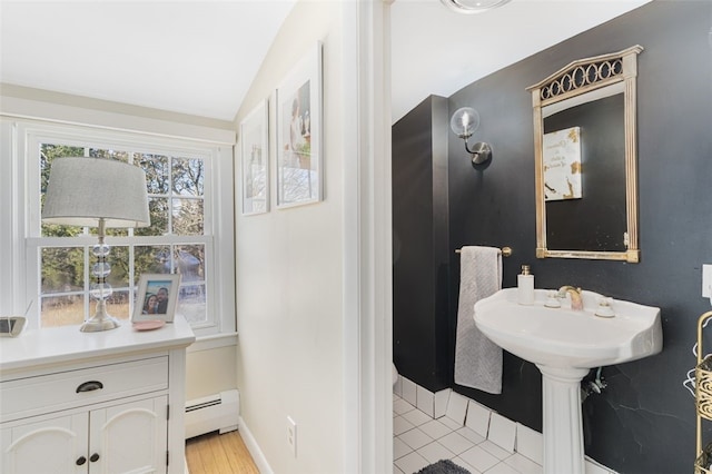 bathroom featuring tile patterned flooring, vaulted ceiling, and a baseboard heating unit