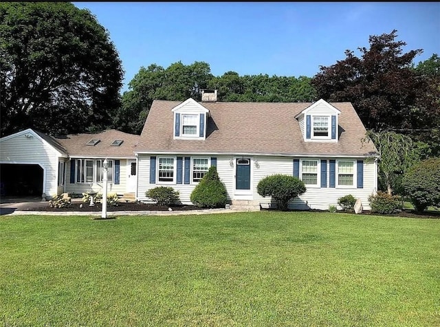 new england style home with a front yard and a garage