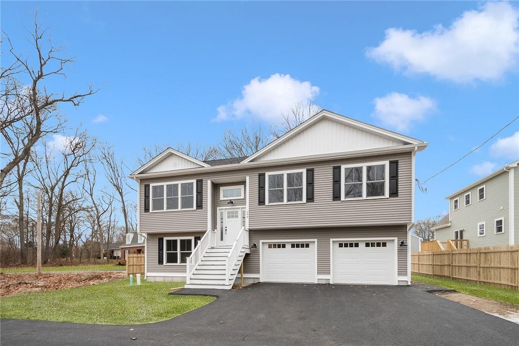 raised ranch with a garage and a front yard