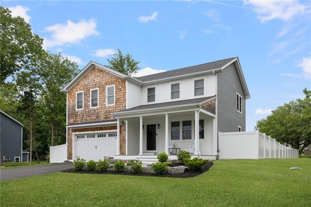 view of front facade featuring a porch, a front yard, and a garage