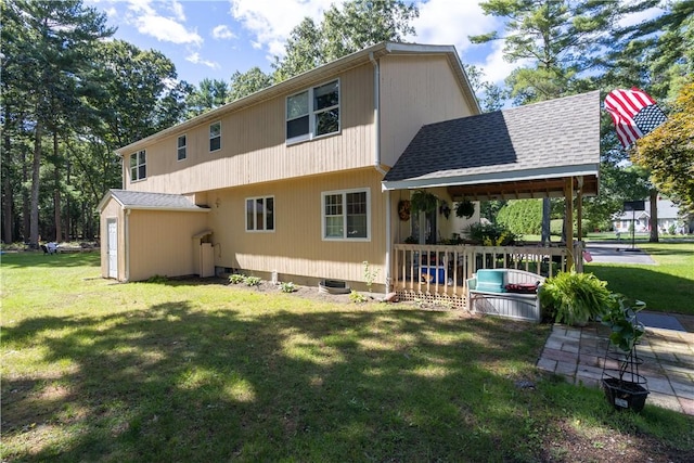 back of property featuring a yard and covered porch