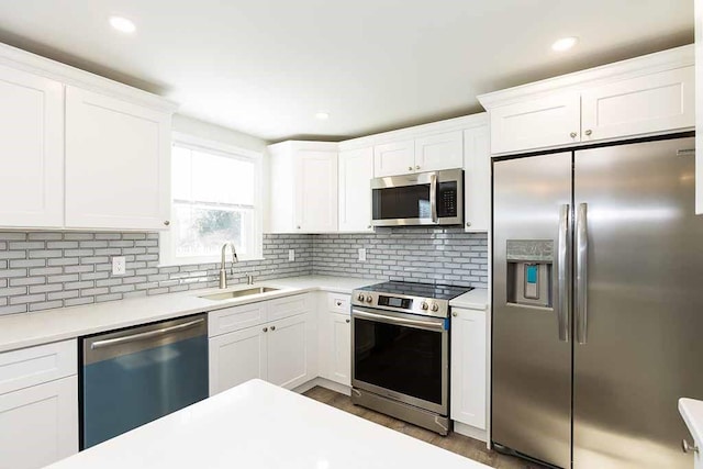 kitchen featuring white cabinets, sink, decorative backsplash, dark hardwood / wood-style floors, and stainless steel appliances