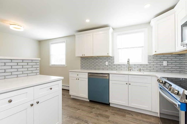 kitchen with sink, baseboard heating, plenty of natural light, white cabinetry, and stainless steel appliances