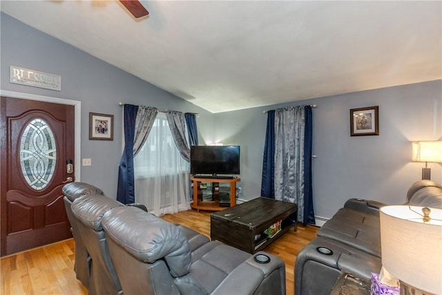 living room with vaulted ceiling, ceiling fan, light hardwood / wood-style flooring, and a baseboard heating unit