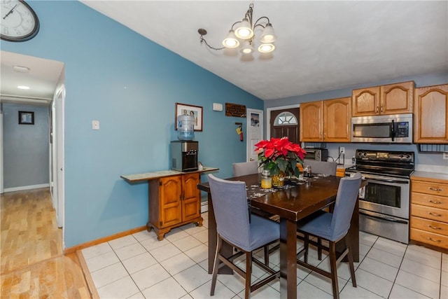 tiled dining space with lofted ceiling and a notable chandelier