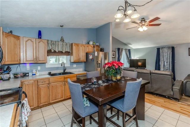 kitchen with decorative light fixtures, sink, appliances with stainless steel finishes, and vaulted ceiling