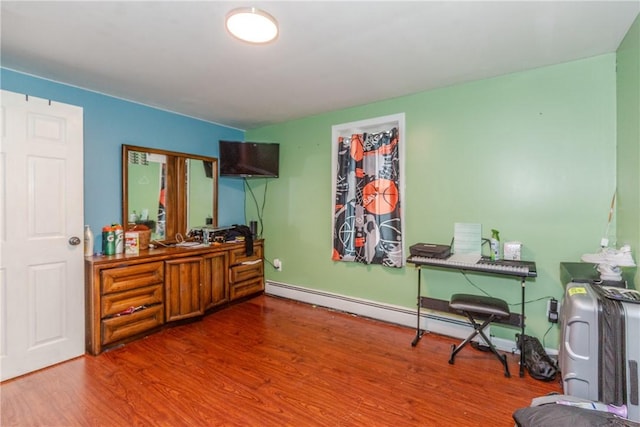 misc room with wood-type flooring and a baseboard heating unit