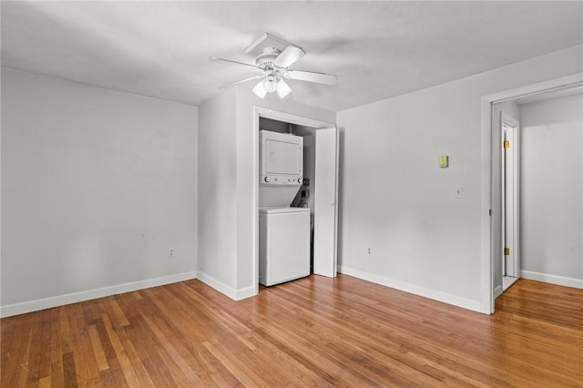 interior space featuring ceiling fan, stacked washer and dryer, and light hardwood / wood-style floors