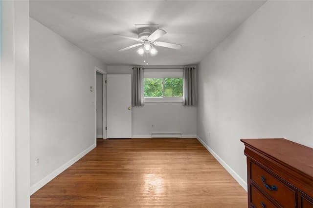 empty room with baseboard heating, ceiling fan, and light hardwood / wood-style floors