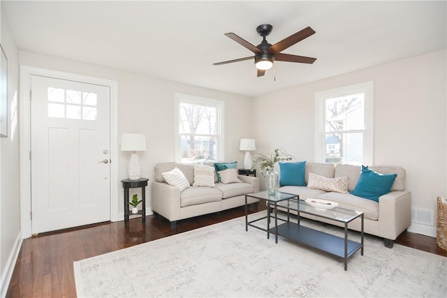 living room with ceiling fan, dark wood-type flooring, and plenty of natural light