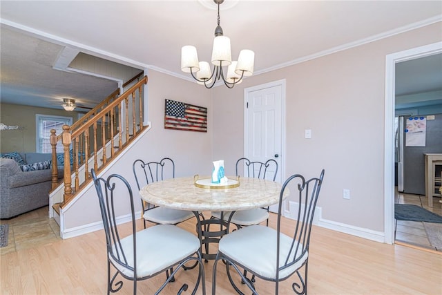 dining space with crown molding, light hardwood / wood-style floors, and a notable chandelier