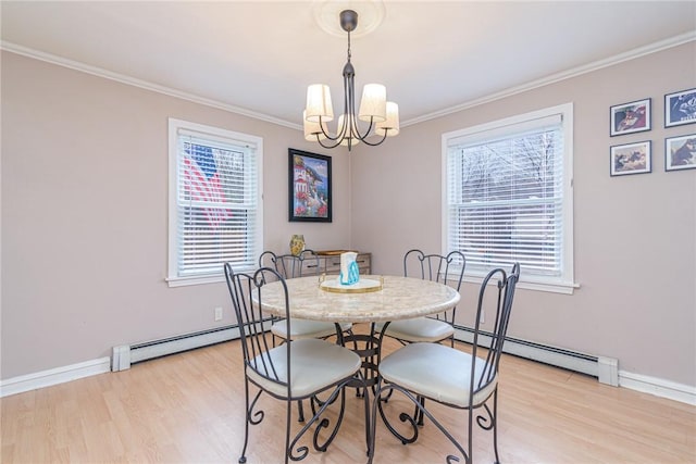 dining room featuring a chandelier, baseboard heating, and a healthy amount of sunlight