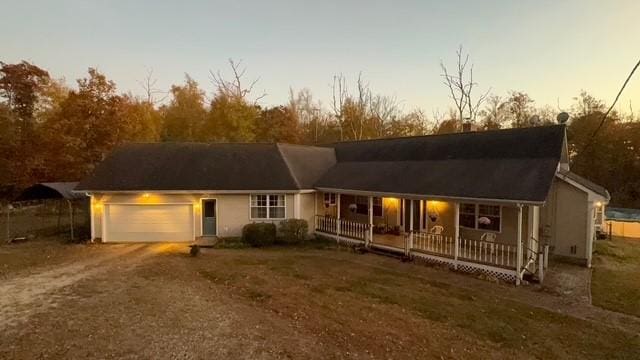 ranch-style house with a porch and a garage