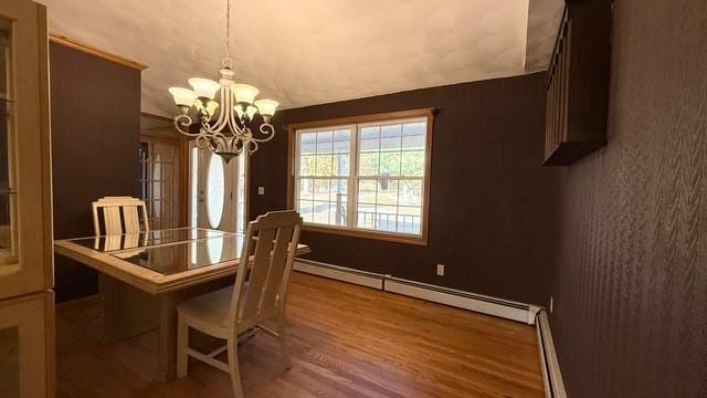 dining area with a baseboard heating unit, wood-type flooring, and a chandelier