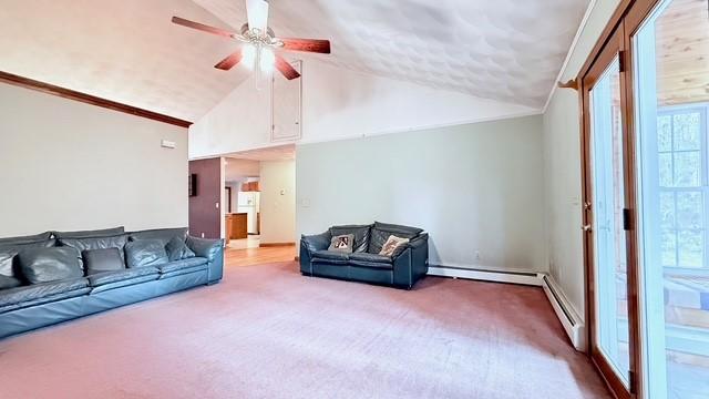 living room featuring lofted ceiling, a baseboard radiator, ceiling fan, and carpet