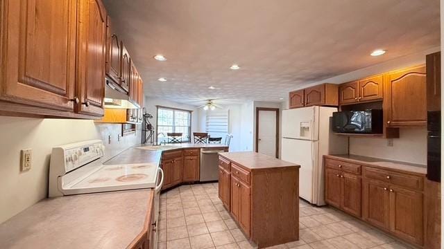 kitchen with ceiling fan, white appliances, and a kitchen island