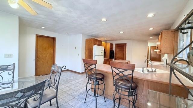 kitchen with white refrigerator, sink, and kitchen peninsula