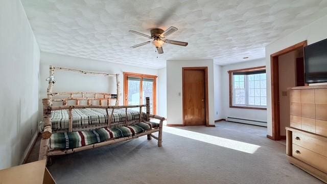 bedroom with baseboard heating, ceiling fan, and carpet floors