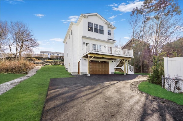 view of front of home with a garage, a deck, and a front lawn