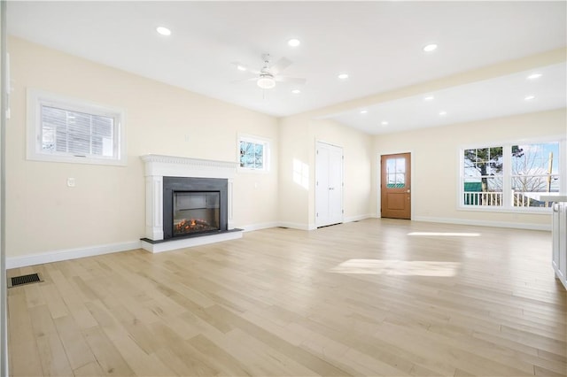 unfurnished living room featuring ceiling fan and light hardwood / wood-style flooring