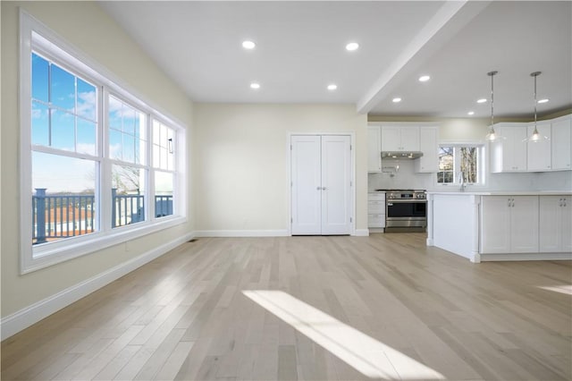 unfurnished living room featuring light hardwood / wood-style flooring and beamed ceiling