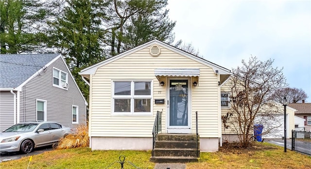 bungalow-style home with a front yard