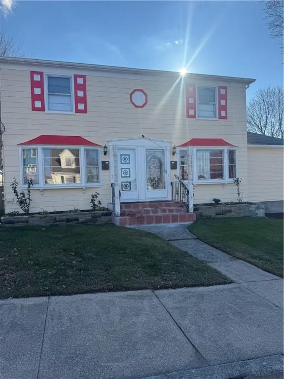 townhome / multi-family property featuring a front lawn