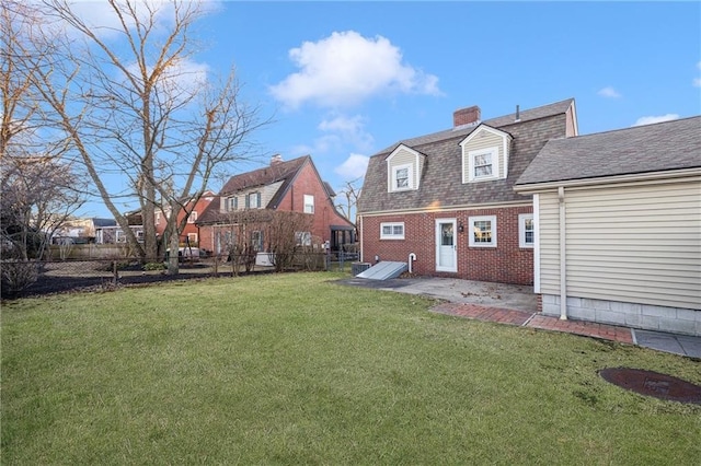 rear view of property featuring a lawn