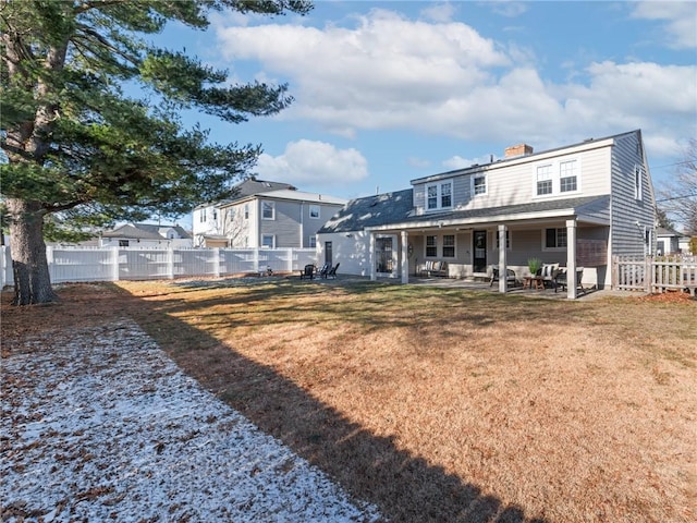 rear view of property with a patio and a yard