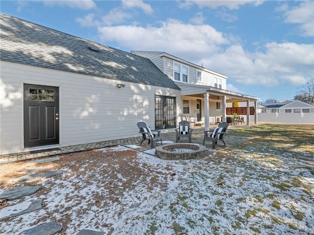 snow covered house featuring a bar, an outdoor fire pit, and a patio