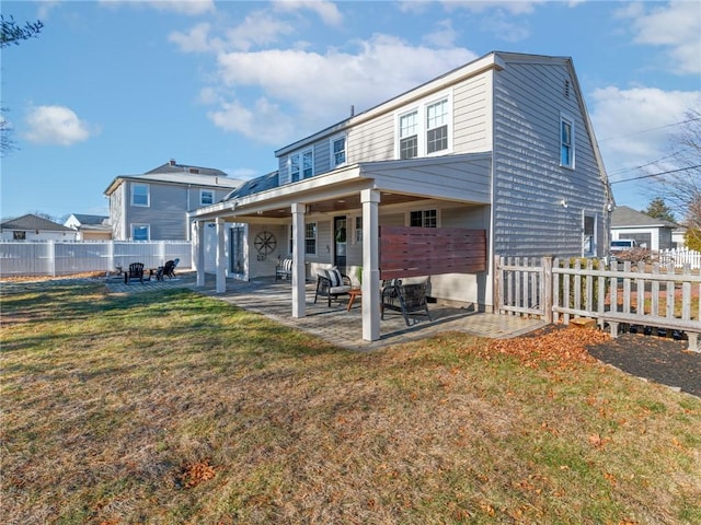 rear view of property featuring a yard and a patio