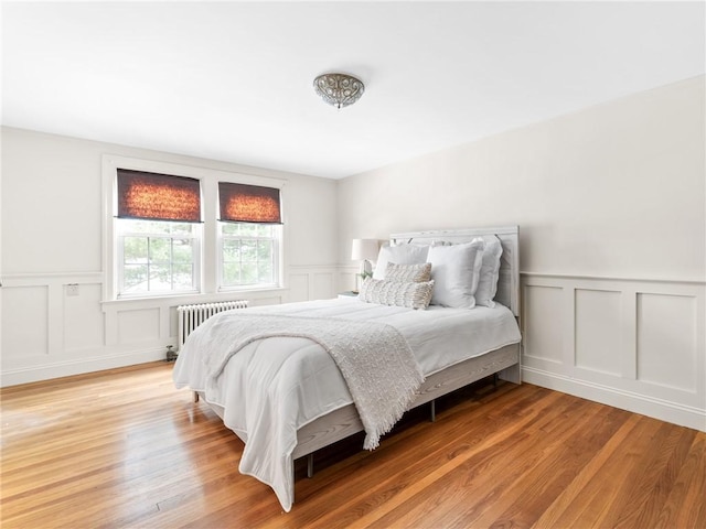 bedroom with hardwood / wood-style flooring and radiator