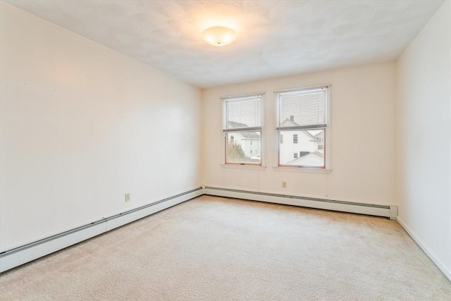 spare room featuring light carpet and baseboard heating