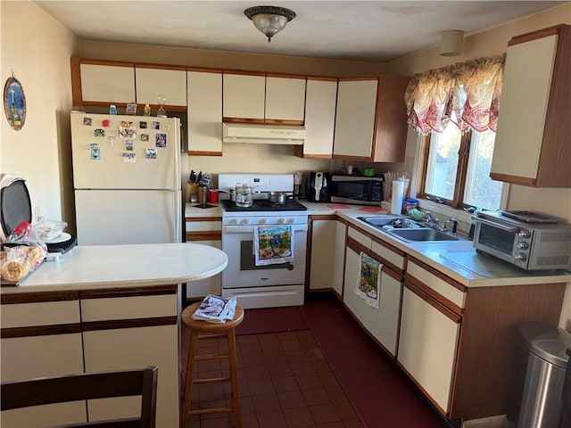 kitchen featuring white cabinets, white appliances, dark tile patterned floors, and sink