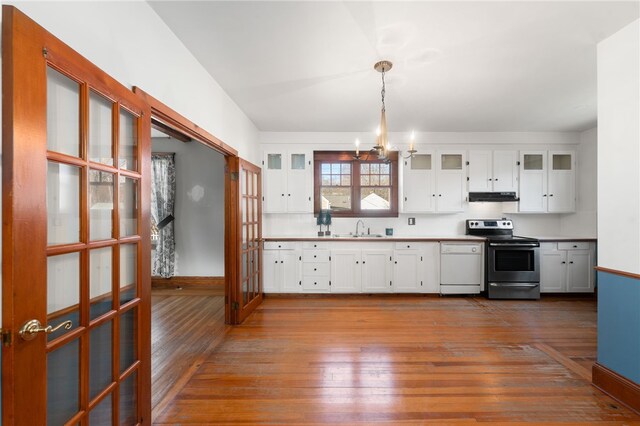 kitchen featuring dishwasher, pendant lighting, electric range, sink, and white cabinets