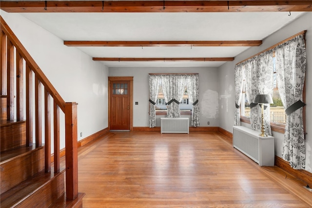 entryway featuring light hardwood / wood-style floors, radiator heating unit, and beamed ceiling