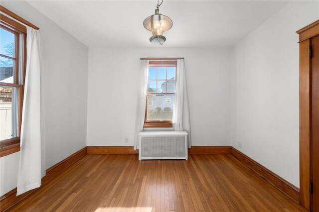 spare room with hardwood / wood-style flooring and radiator heating unit