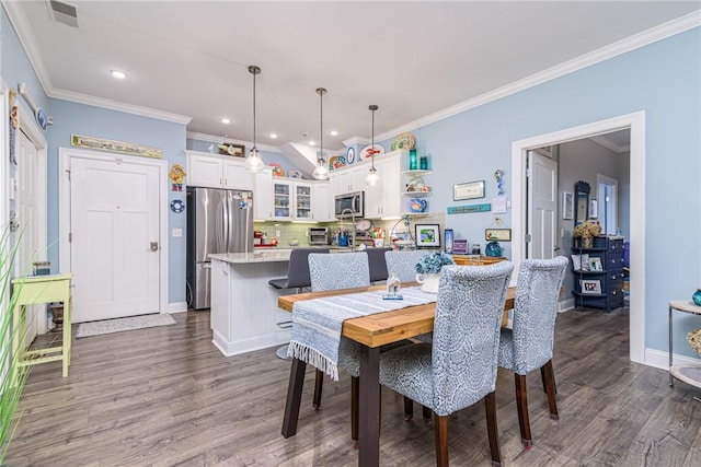 dining space with ornamental molding and dark wood-type flooring