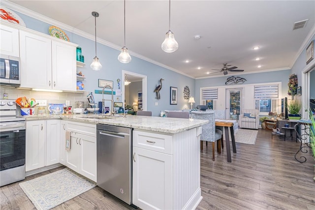 kitchen with white cabinets, stainless steel appliances, pendant lighting, and ceiling fan