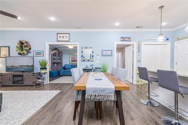 dining area featuring crown molding and dark wood-type flooring