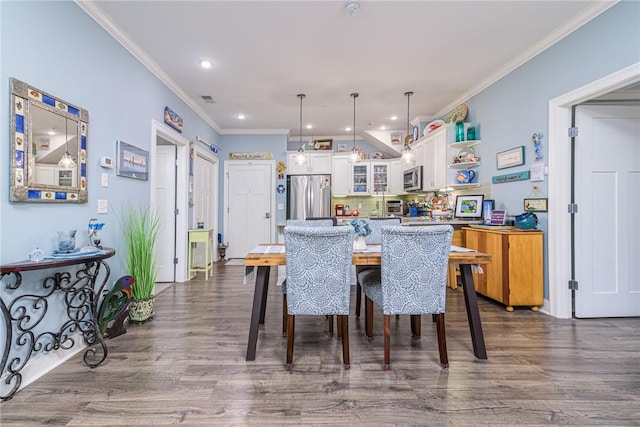 dining room with crown molding and dark hardwood / wood-style floors