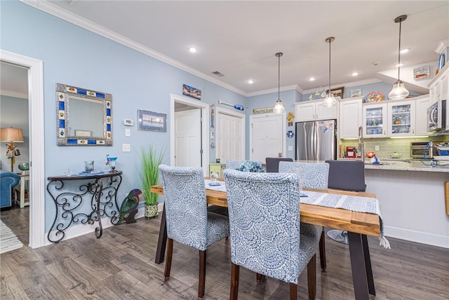 dining area with crown molding and dark hardwood / wood-style floors